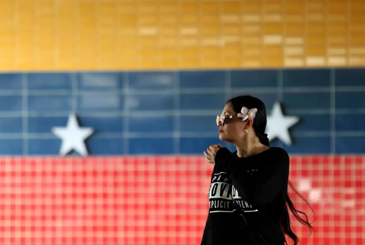 Archivo - Una mujer pasa ante un mural con la bandera de Venezuela - Europa Press/Contacto/Juan Carlos Hernandez