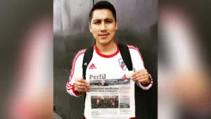 un lector del diario PERFIL posa con la primera edicion impresa